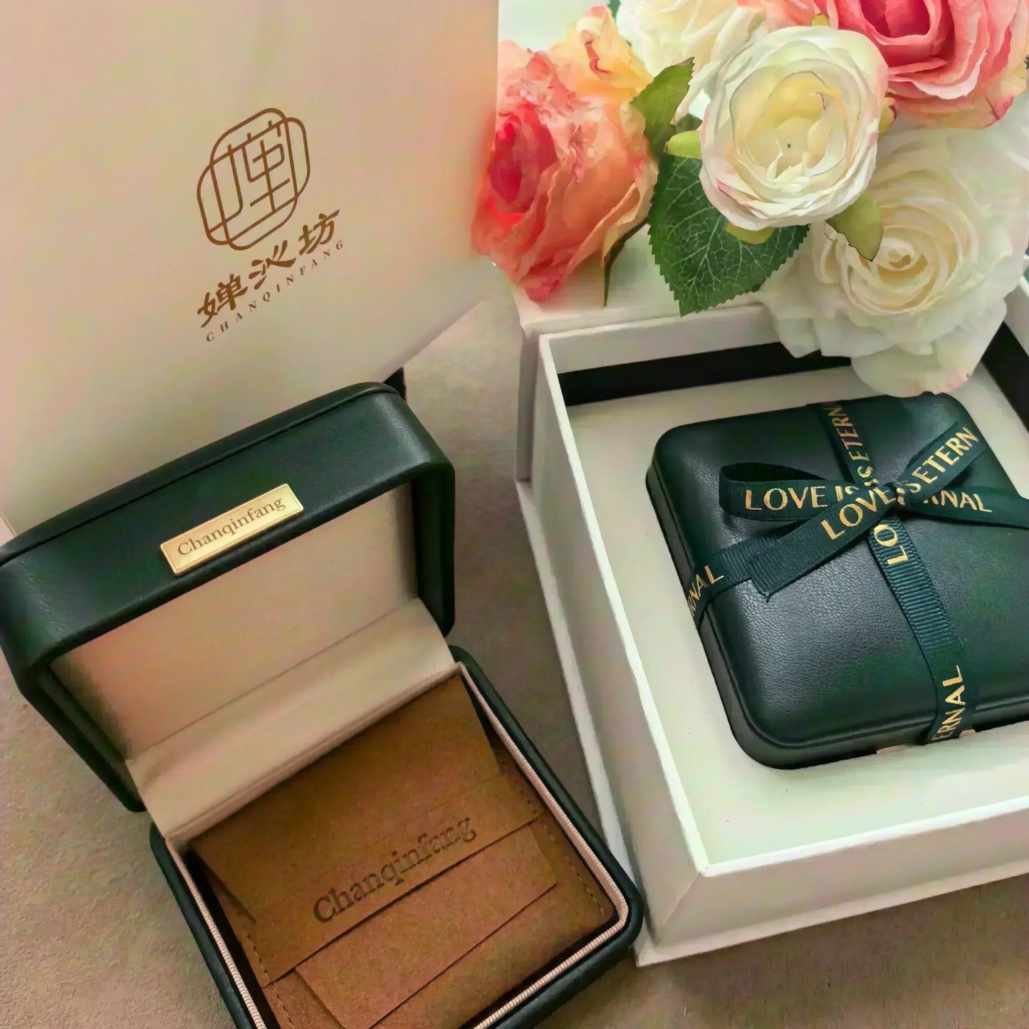 Chanqinfang black and beige jewelry boxes with branded logo and ribbon, accompanied by pink and white roses