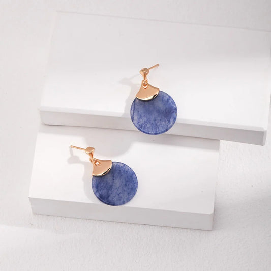 Elegant blue round stone drop earrings with gold-tone metal accents on white display