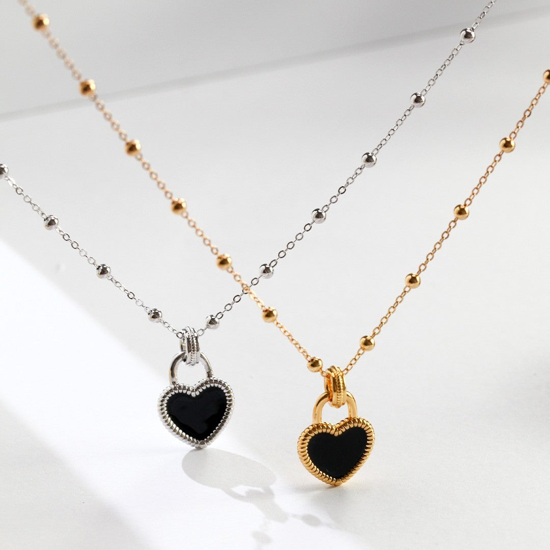 Close-up of a woman wearing a delicate gold necklace with a blue gemstone pendant, styled with a white ribbed top