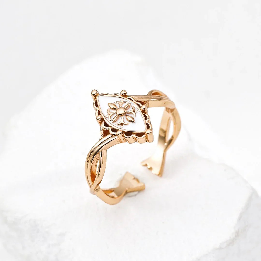 Elegant gold ring with a blue teardrop gemstone and small diamonds on a woman's hand